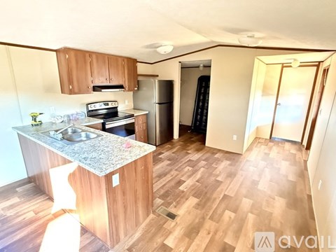 A kitchen with wooden cabinets and a granite countertop.