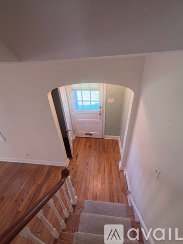 A staircase with wooden steps and a carpeted runner leads to a doorway.