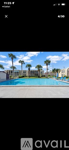 A pool surrounded by palm trees and buildings.