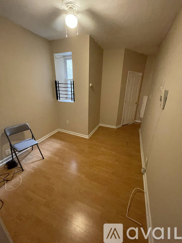 A room with a wooden floor and a chair.