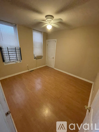 A room with wooden flooring and a ceiling fan.