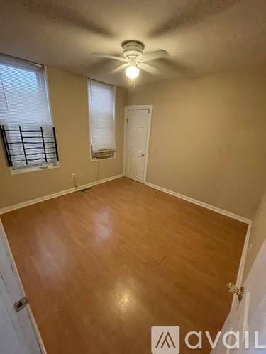 A room with wooden flooring and a ceiling fan.