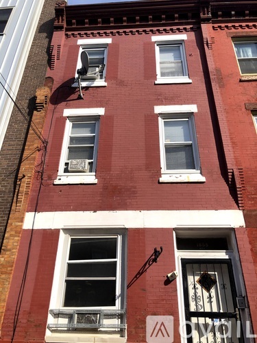 A red brick building with white windows and a white door.