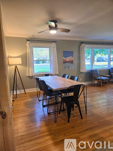 A dining room with a wooden table and chairs.