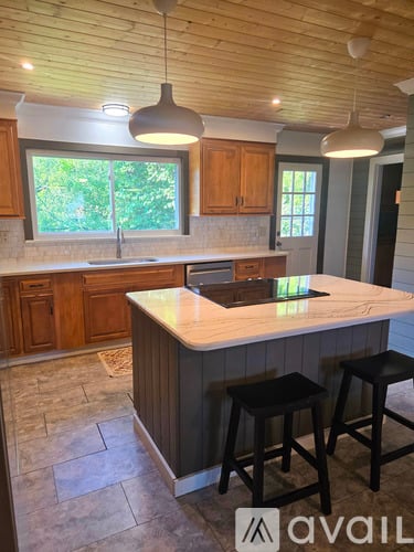 A kitchen with wooden cabinets and a marble countertop.