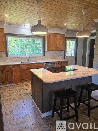 A kitchen with wooden cabinets and a marble countertop.