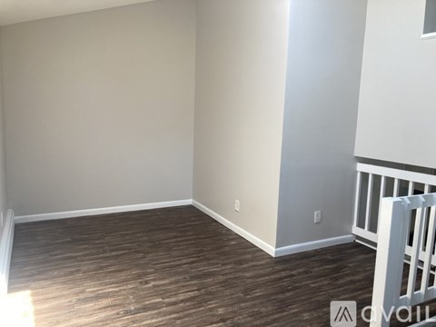 A room with wooden flooring and white walls.