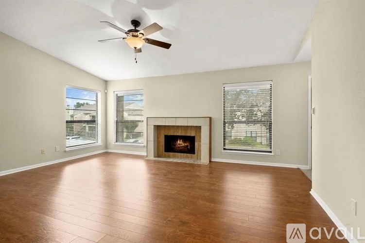 A living room with a fireplace and a ceiling fan.