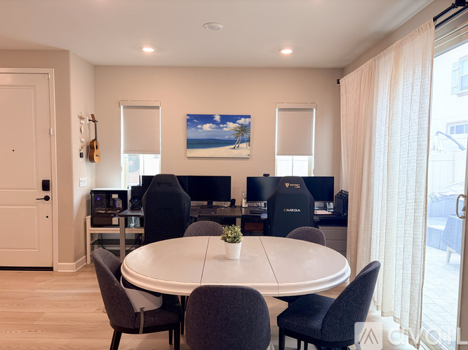A dining room with a round table and chairs.