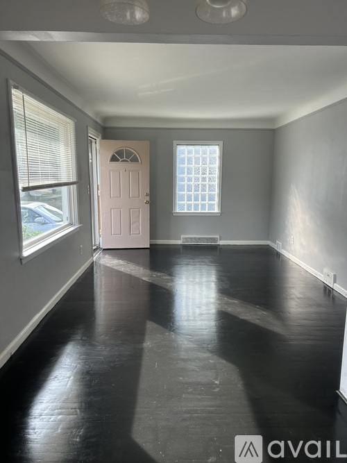 A room with a white door and a window with blinds.