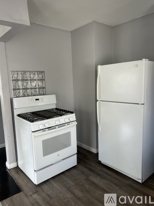 A white stove and refrigerator in a kitchen.