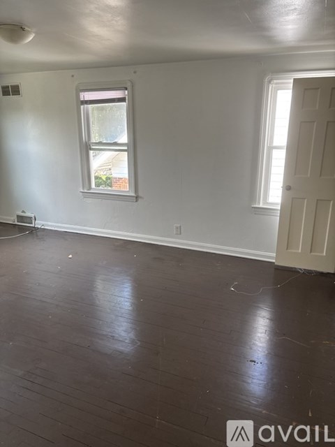 A room with a window and wooden floors.