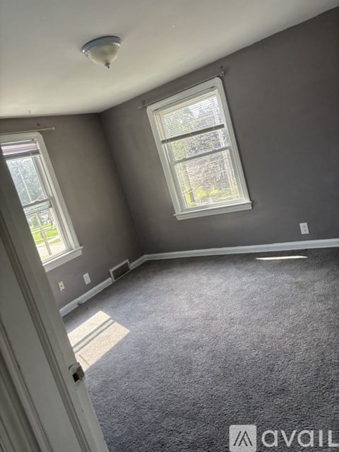 A room with a carpeted floor and a window.