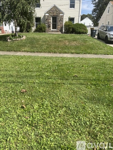A house with a green lawn in front of it.