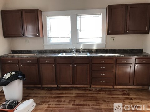 A kitchen with brown cabinets and a black countertop.