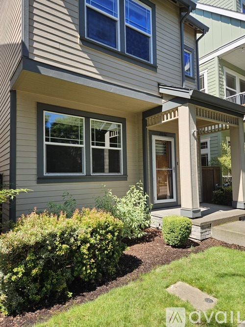 A house with a grey siding and a white door.