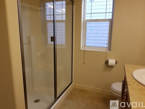 A bathroom with a glass shower door and a toilet.
