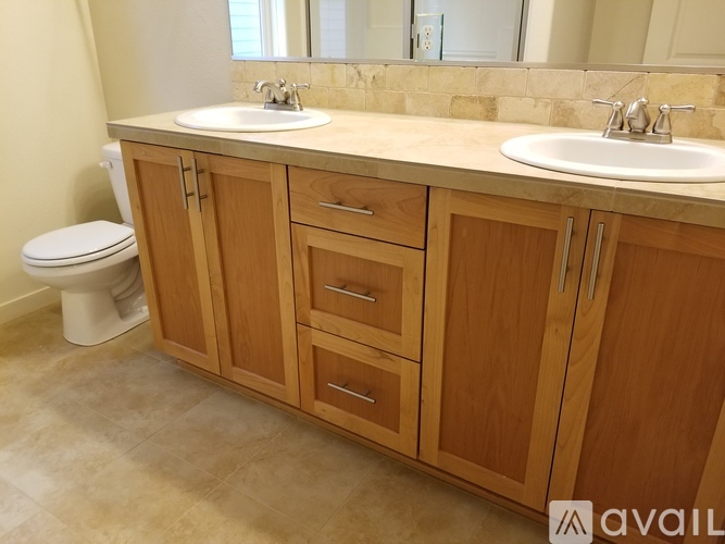 A bathroom with wooden cabinets and a white toilet.