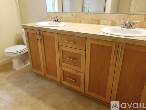 A bathroom with wooden cabinets and a white toilet.
