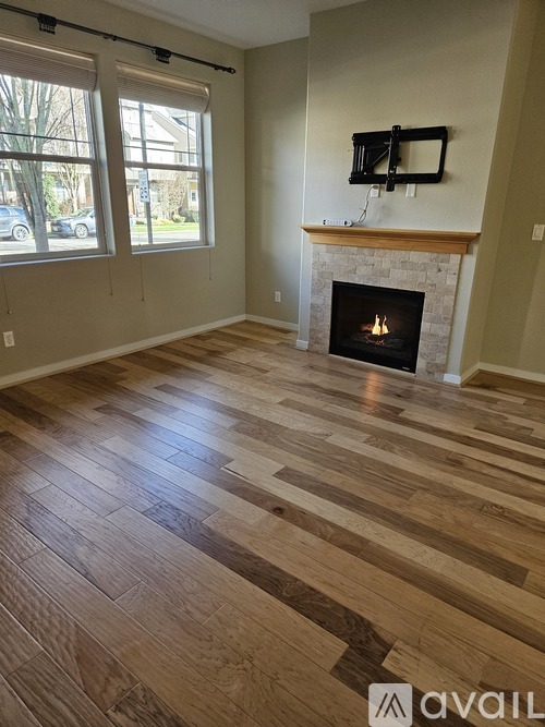 A room with a fireplace and wooden flooring.