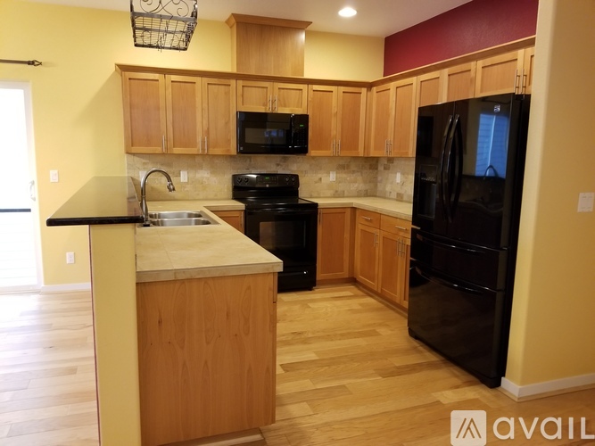 A kitchen with wooden cabinets and black appliances.