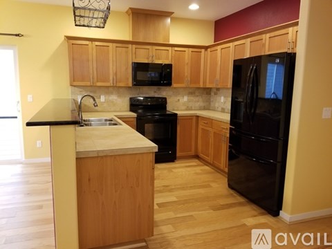 A kitchen with wooden cabinets and black appliances.