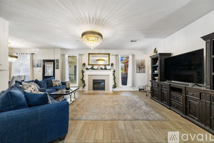 A living room with a fireplace and a blue couch.