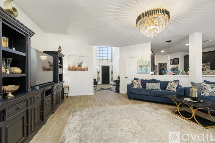A living room with a blue couch and a chandelier.