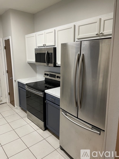 A kitchen with a stainless steel refrigerator, oven, and microwave.