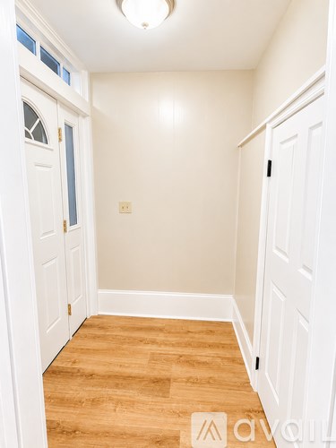 A hallway with white doors and wooden floors.