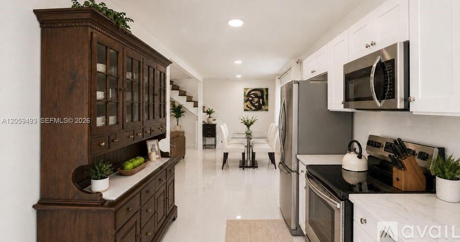 A modern kitchen with white cabinets and a wooden island.