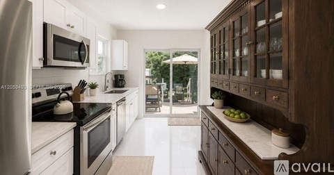 A modern kitchen with dark wood cabinets and white appliances.