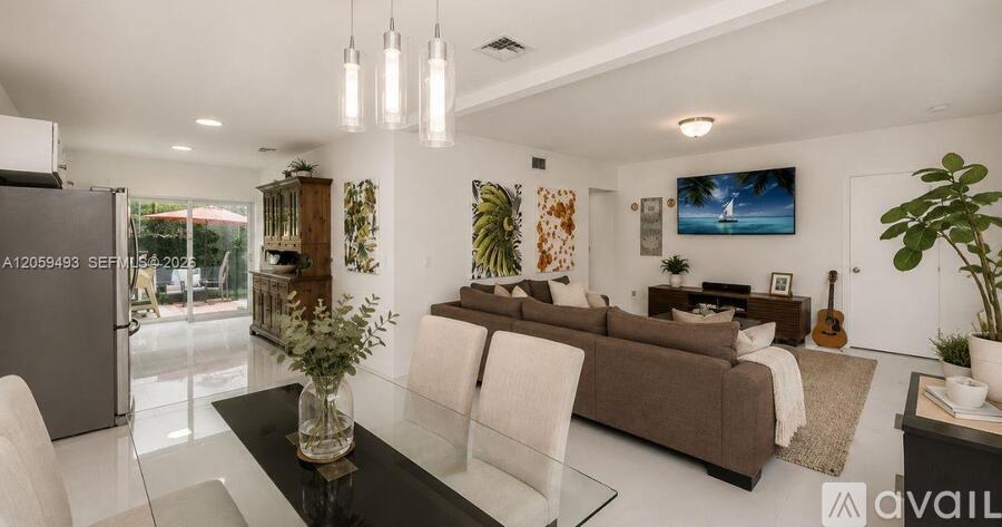 A modern living room with a glass table and a brown sofa.