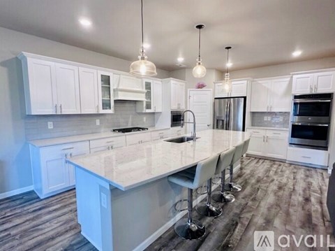 A kitchen with white cabinets and a large island.