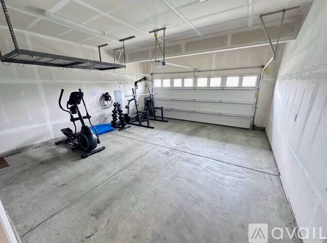 A gym with a treadmill, elliptical trainer and a stationary bike.