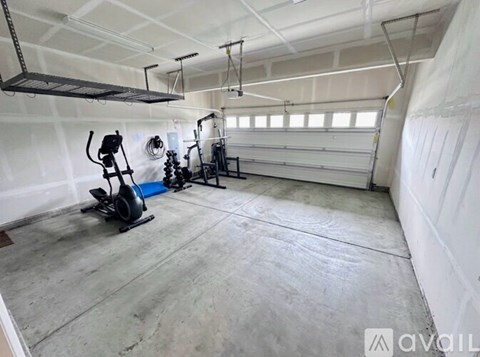 A gym with a treadmill, elliptical trainer and a stationary bike.