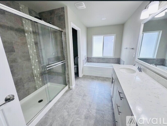A modern bathroom with a walk-in shower and double sinks.