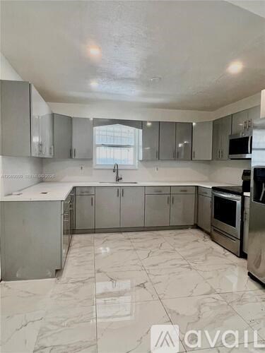 A kitchen with marble flooring and stainless steel appliances.