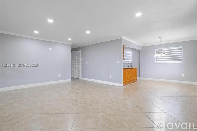 A spacious room with a tiled floor and a wooden cabinet.