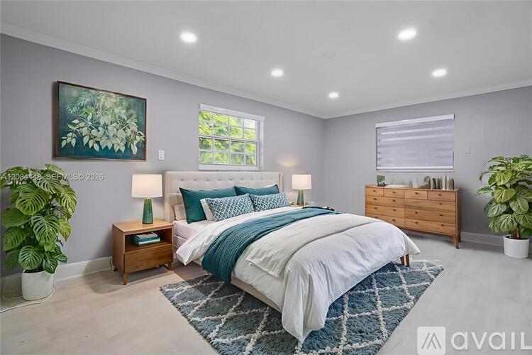 A bedroom with a large bed, a nightstand with a lamp, and a painting on the wall.