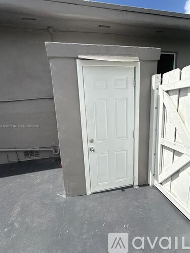 A white door is closed and has a metal latch.