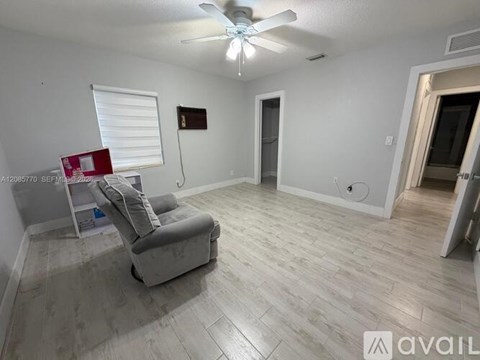 A room with a ceiling fan and a chair.