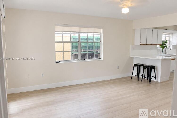A room with a window and a bar stool.