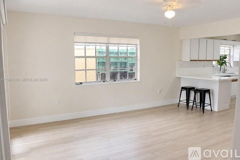A room with a window and a bar stool.