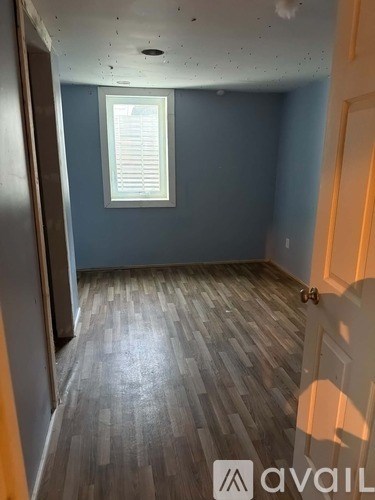 A room with wooden flooring and a window.