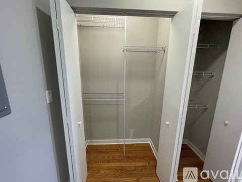 A walk-in closet with a glass door and shelves.