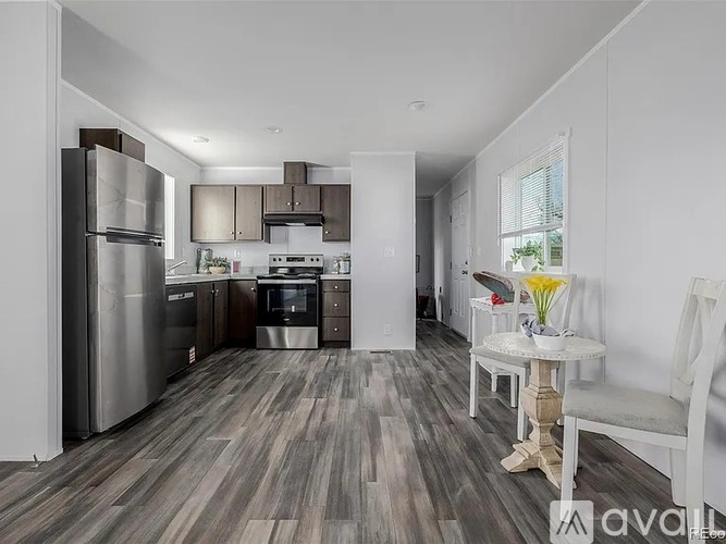 A kitchen with a refrigerator, oven, and sink.