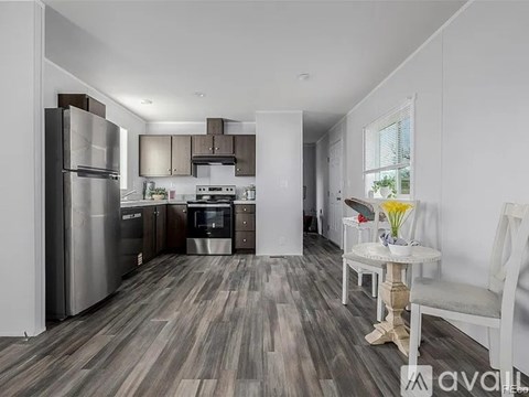 A kitchen with a refrigerator, oven, and sink.
