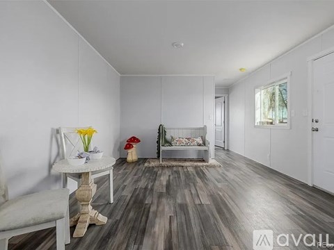 A living room with a grey sofa and a white table.