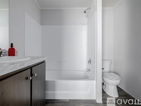 A white bathroom with a tub, toilet, and sink.